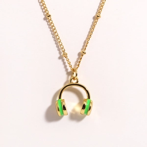 Detailed view of golden necklace with cool neon green headphone pendant on white background