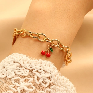 Bracciale a catena dorata con ciondolo a ciliegia e perle bianche da donna al polso