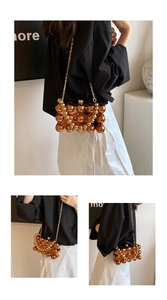 Detailed view of the golden acrylic spherical beaded evening bag with chain strap