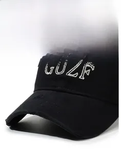 Detail of vintage black baseball cap featuring pearl GUZF letters and distressed brim