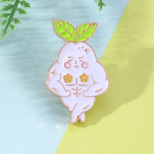 Close-up of a cartoon white radish enamel pin with golden edges on a colorful background