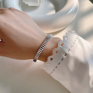 Minimalist S925 sterling silver cuff bracelet with irregular pleated texture on wrist