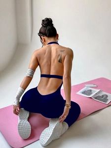Detail of navy blue backless yoga jumpsuit showing high-stretch fabric and waist support strap
