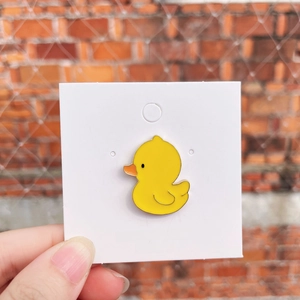 Cute yellow duck enamel pin badge for backpacks and pencil cases shown in hand