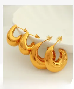 Detail of two pairs of polished gold hollow C-shape earrings in various sizes
