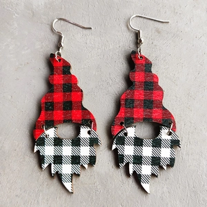 Detail of Christmas gnome earrings with red leopard and black plaid wood texture