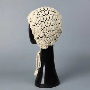 Détail d'un chapeau au crochet bohème ivoire avec motifs ajourés et accent floral chic