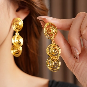 Close-up of vintage golden swirl flower earrings on model showcasing metallic luster