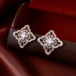 Luxury gold hollow flower stud earrings with sparkling zircons on elegant brown leather