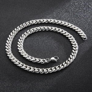 Detailed close-up of silver Cuban chain necklace with lobster clasp and cut-edge design