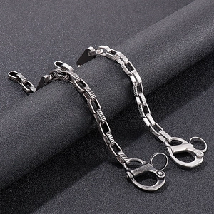 Detail of vintage silver titanium steel chain with double lobster clasps on black texture