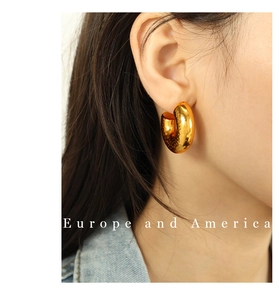 Close-up of woman wearing thick 18K gold plated chunky hoop earrings with mirror finish
