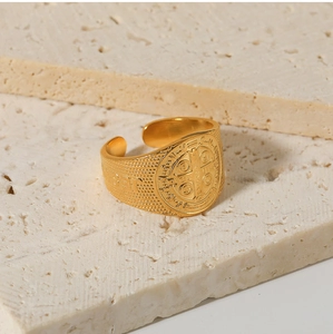 Detailed view of Saint Benedict vintage gold ring with religious engravings on stone