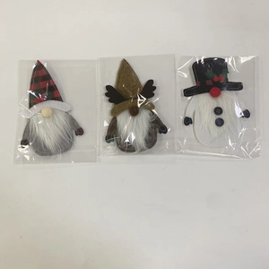 Detail of Christmas gnome and snowman cutlery holders in festive red and black plaid fabric