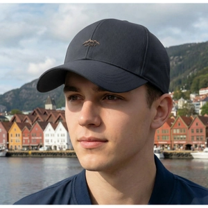 Detail of dark grey breathable baseball cap with mountain logo on travel background