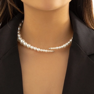 Close-up of white gradient pearl choker with metallic clasp detail on model neck