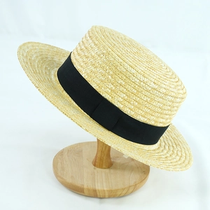 Dettaglio della trama di un cappello di paglia intrecciata con elegante nastro nero e tesa