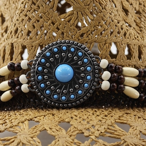 Macro detail of western cowboy hat band with turquoise gemstone and vintage metal buckle