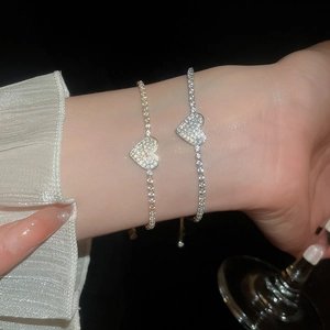 Close-up of sparkling zircon heart tennis bracelets in gold and silver finish