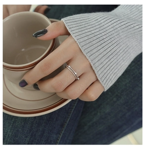 Close-up of a double-layered sterling silver ring with small zircons on a model's hand