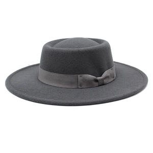 Close-up of a dark grey wool felt boater hat with a wide brim and ribbon bow detail