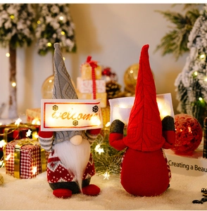 Detail of Christmas gnome plush doll with a glowing welcome sign in festive holiday setting