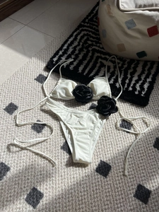 Close-up of cream bikini set with large black 3D rose petals and drawstring details