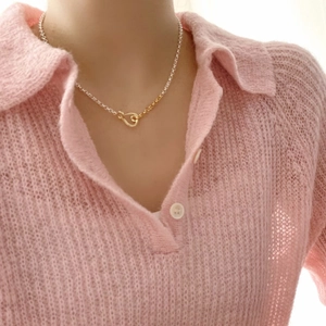 Close-up of minimalist two-tone silver and gold chain necklace on a model