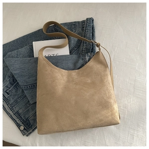Detail of khaki faux suede tote bag on denim fabric with a minimalist casual aesthetic
