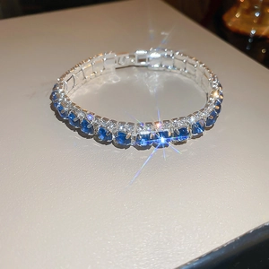 Macro shot of silver tennis bracelet with sparkling blue sapphires and white zircons