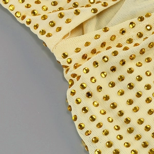 Vue détaillée du tissu en maille avec strass dorés sur une robe moulante sexy