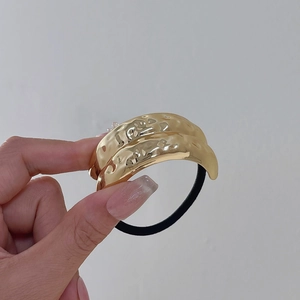 Minimalistisches Haargummi aus gehämmertem Goldmetall mit hochelastischem schwarzem Band