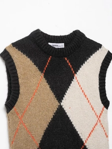 Detail of argyle knit vest featuring classic diamond pattern and ribbed hem textures