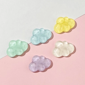 Flat lay of colorful translucent resin cloud charms in mint, blue, yellow, and lavender