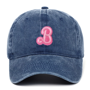 Detail of pink towel-embroidered letter B on a dark blue washed denim baseball cap