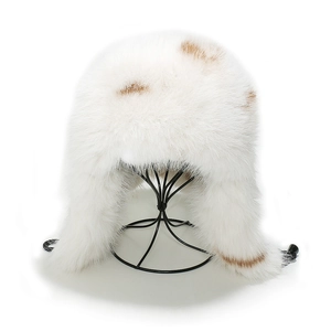 Close-up of white faux fox fur trapper hat with brown spots and thermal ear flaps