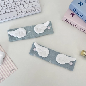 Macro shot of blue denim fabric cable organizers with white plush angel wings and snap button