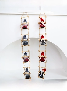 Close-up of wool felt Santa gnome ornaments hanging on wooden sticks for Christmas decor