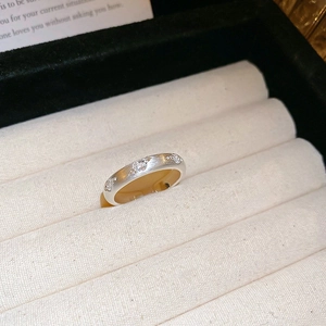 Macro detail of silver wave ring with matte brushed texture and three white inlaid stones