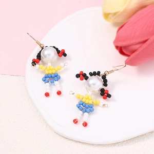 Detail shot of handmade beaded doll earrings featuring colorful faux pearls and textures