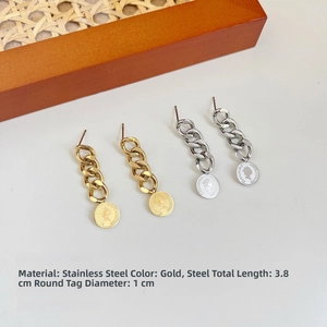 Detailed macro view of stainless steel coin earrings with chain and queen head engraving