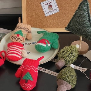 Close-up of knitted mini Christmas mittens featuring festive red and green holiday patterns