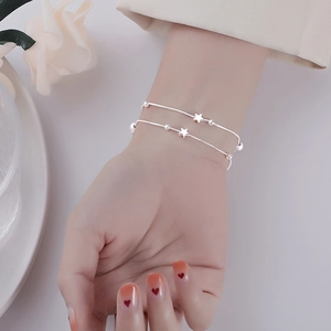 Double-layered silver star bracelet featuring delicate snake chains and star charms