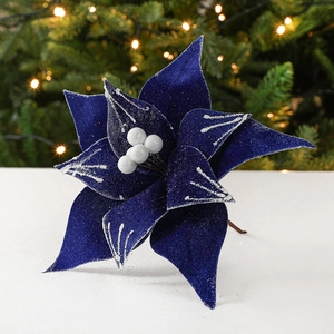 Blue velvet poinsettia Christmas flower with silver glitter on white tabletop