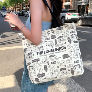 Minimalist canvas tote bag with black cartoon prints for women, shown in an outdoor setting
