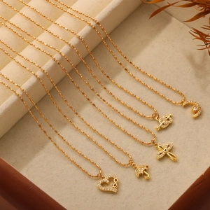 Gold-plated titanium necklaces with heart, butterfly, and moon charms in a jewelry box