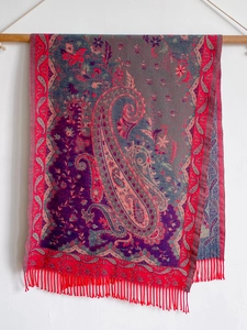 Detail of red and purple paisley pattern cashmere scarf with decorative tassels