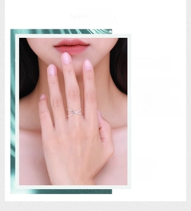 Detail shot of minimalist S925 silver crossover geometric ring on a model hand