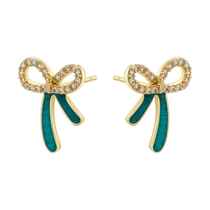Close-up of golden bow earrings with sparkling white zircons and green enamel finish