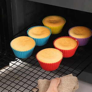 Colorful silicone muffin cups with baked sponge cakes inside an oven rack setting